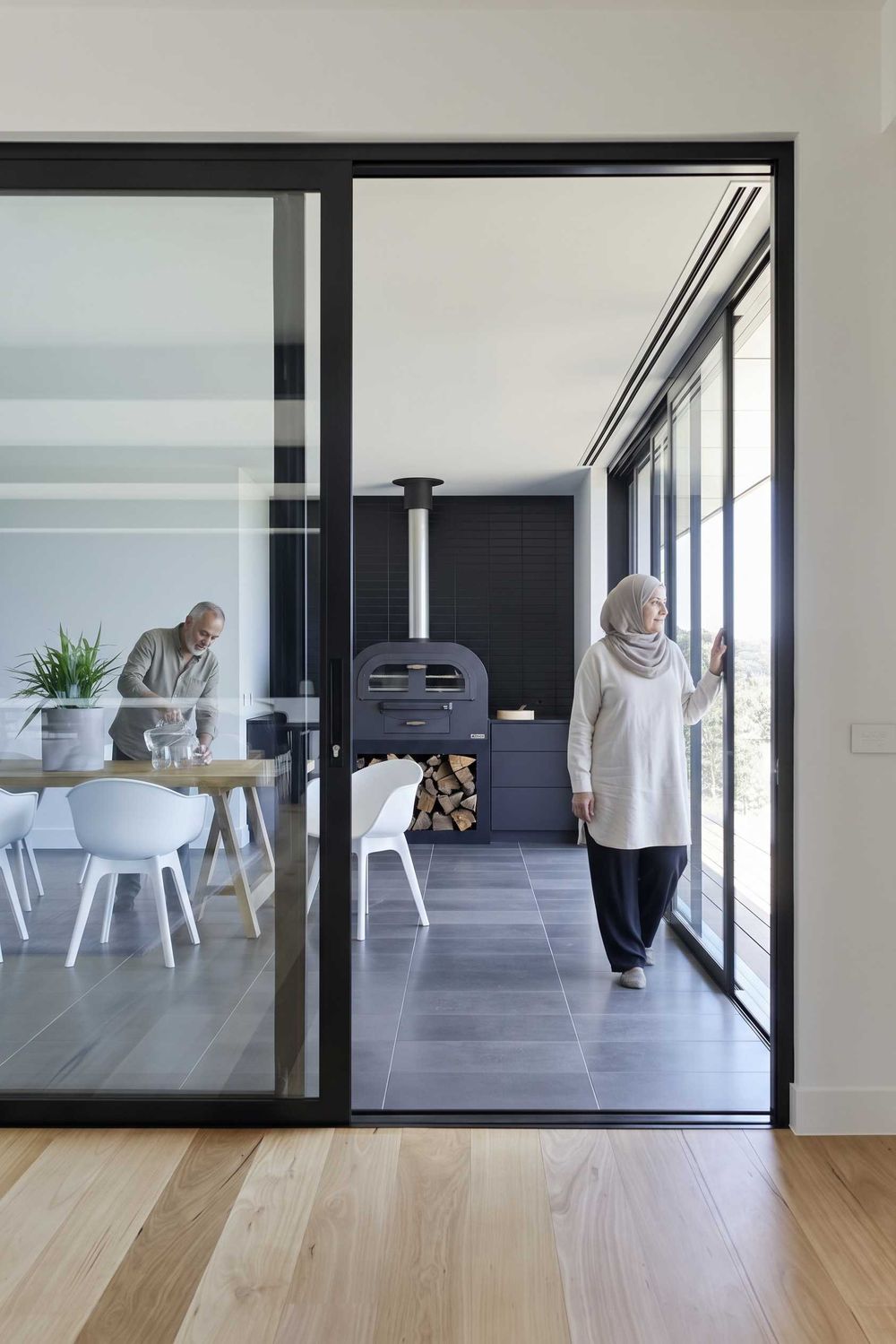 Black-framed sliding door between dining room and alfresco kitchen