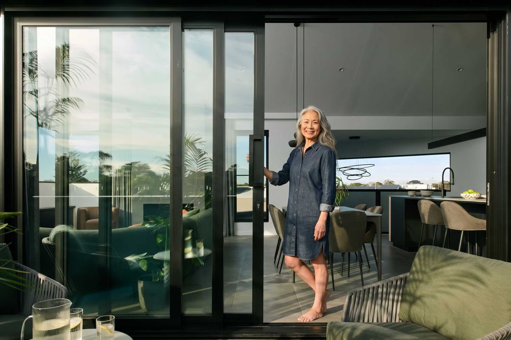 Black multi-panel aluminium sliding doors opening to a balcony